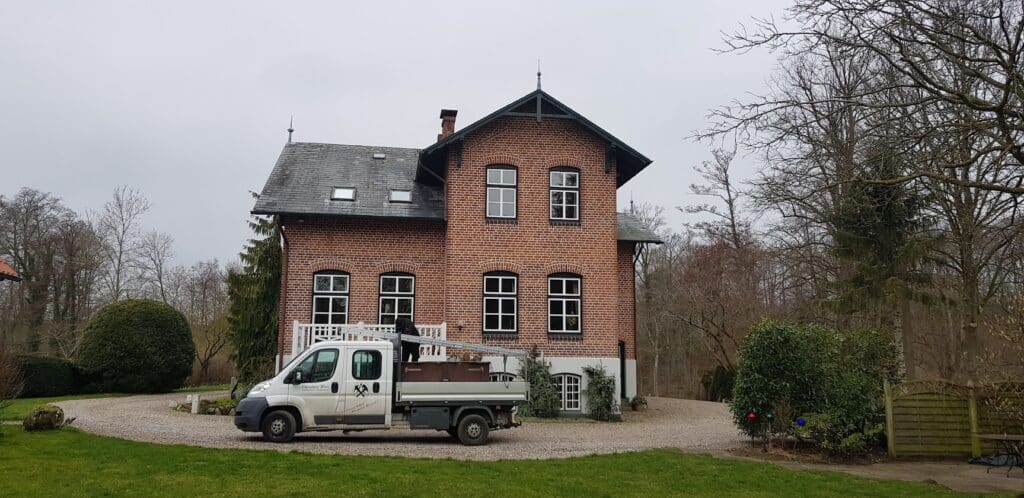 Historisches Backsteinhaus mit älterer Dacheindeckung vor Beginn der Dachsanierung.